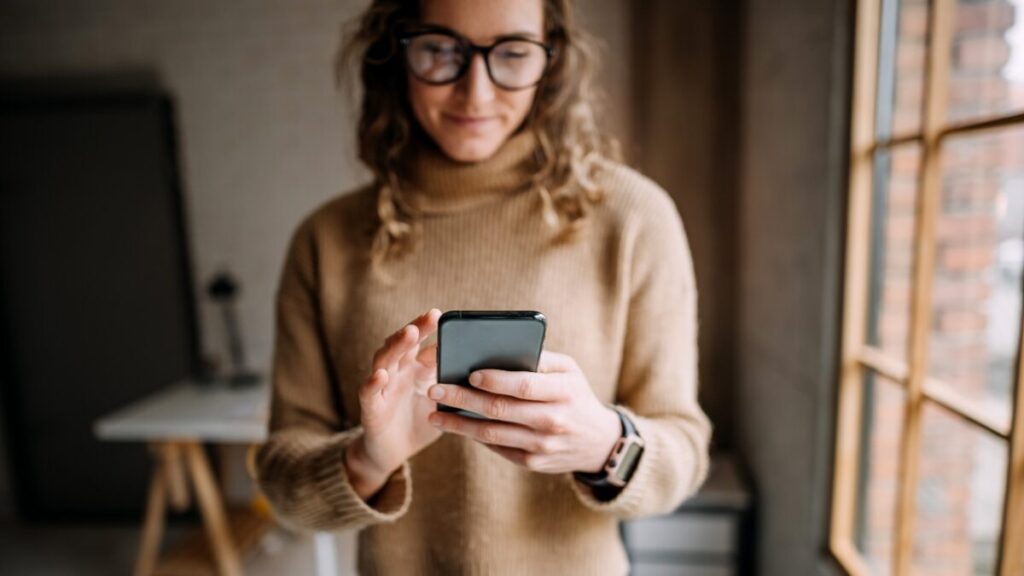 Woman with glasses reading emails on a phone