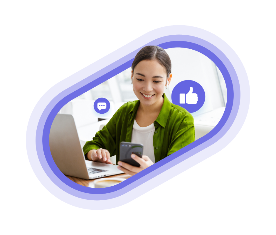 A person in a green jacket using social media on their phone and laptop